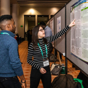 ACPA member pointing at a research poster with onlooker