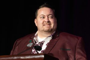 Chris Moody standing at a microphone looking over to the right