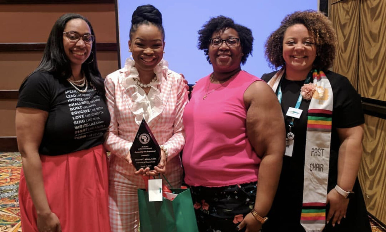 Group of 4 PAN women smiling for a photo holding an award