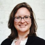 A headshot of Tori Rehr. A White woman with glasses and brown hair smiling.