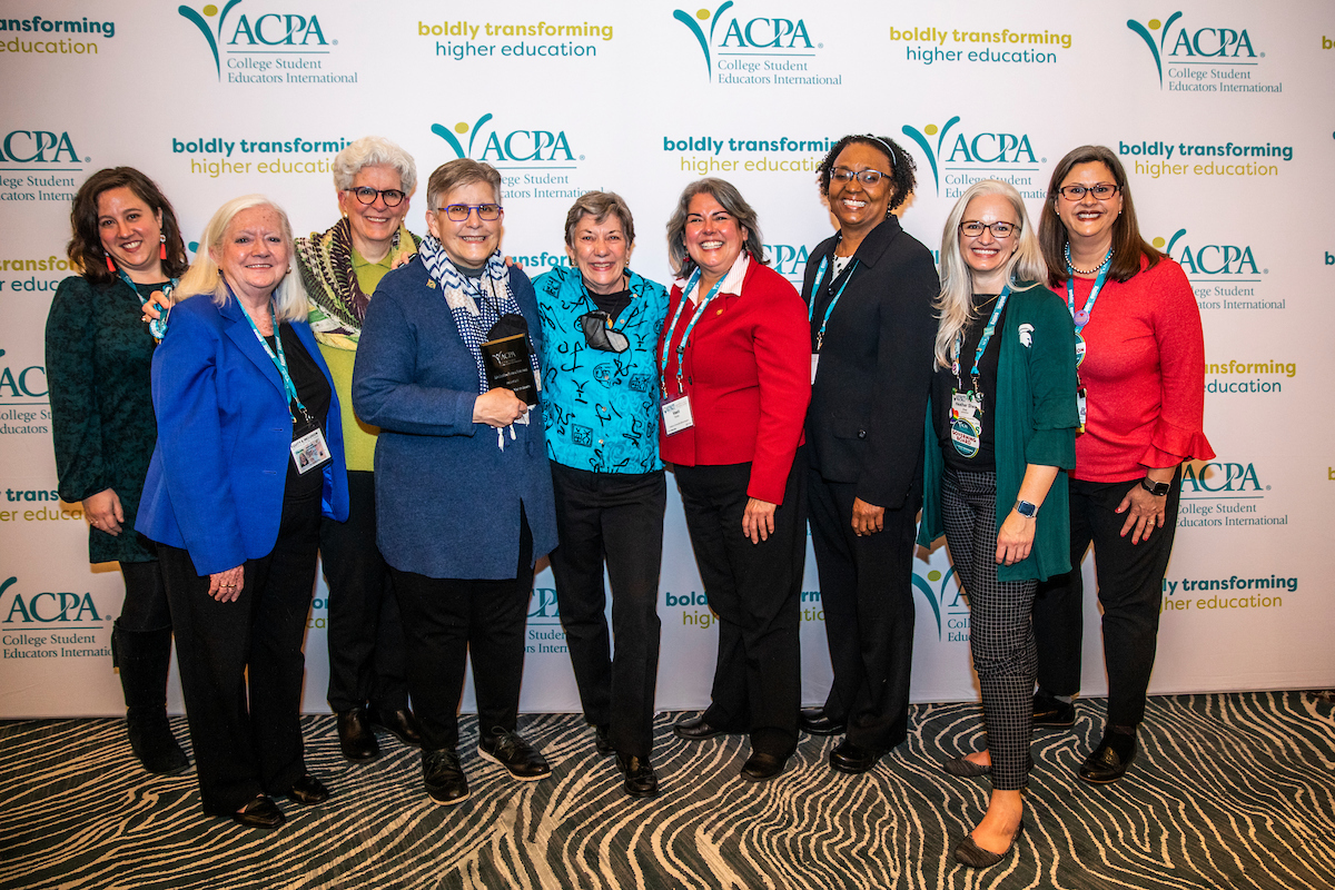 photo of ACPA member receiving an award surrounded by their support network