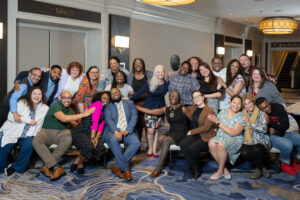 group photo of Governing Board members with smiles and hands in the air showing excitement